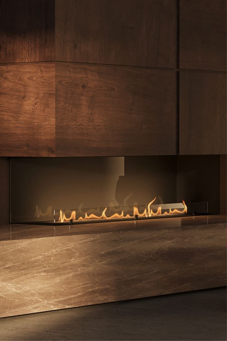 A long bioethanol burner set into a dark timber wall above a marble hearth.